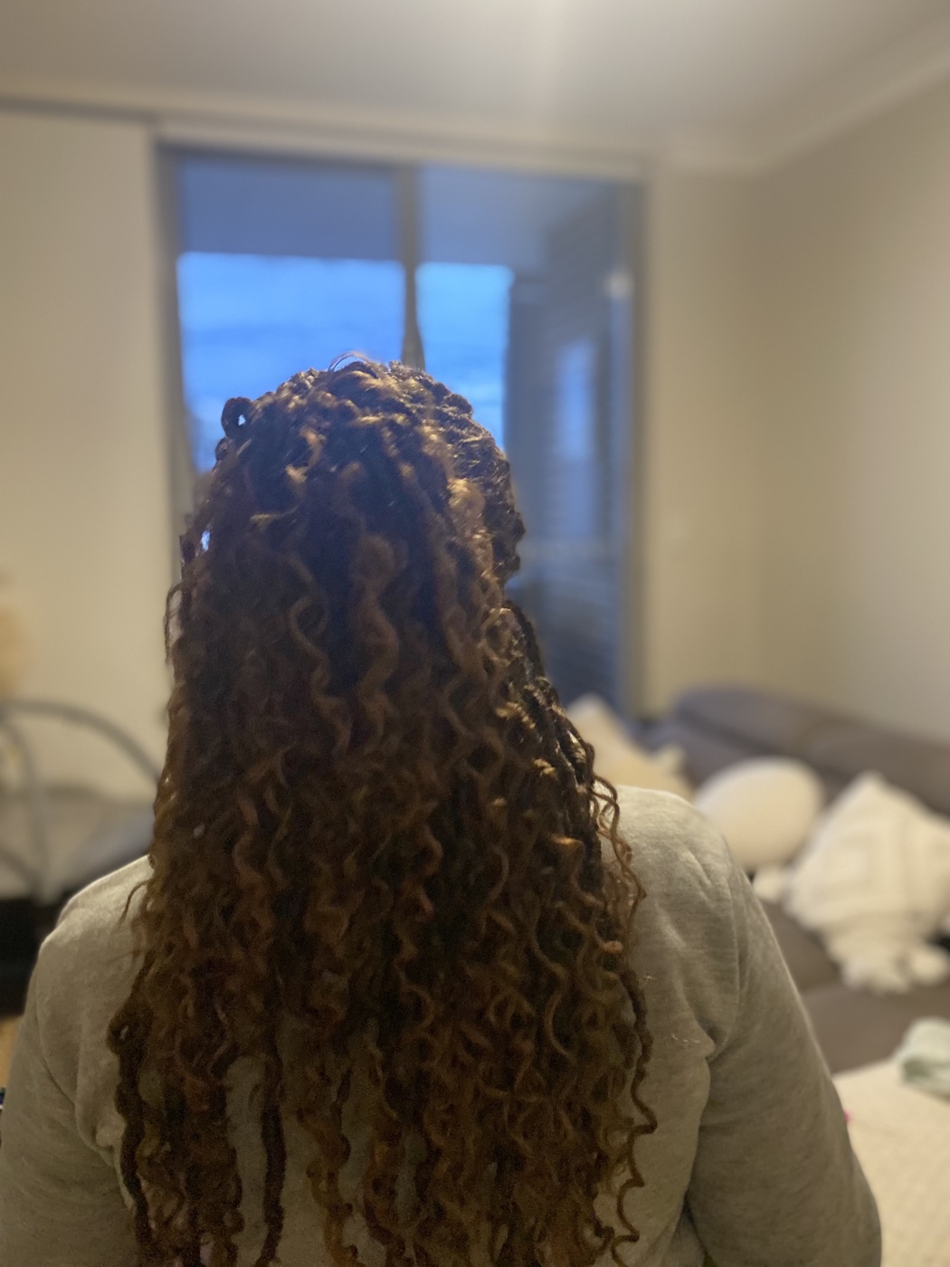 Long boho braids with curly cascading ends, back view.